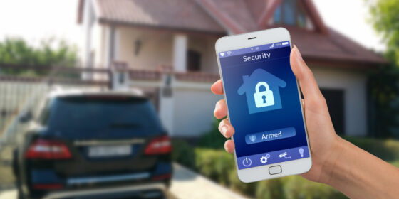 Smartphone with home security app in a hand