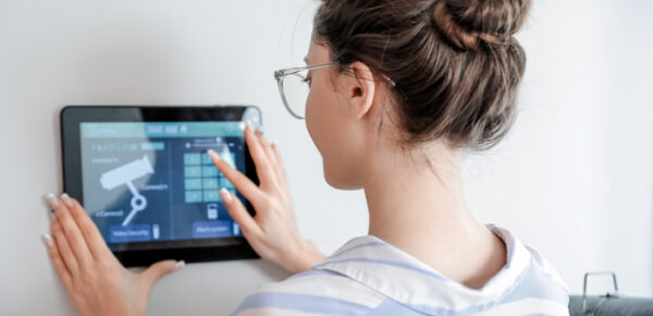 Woman using smart home security system control panel